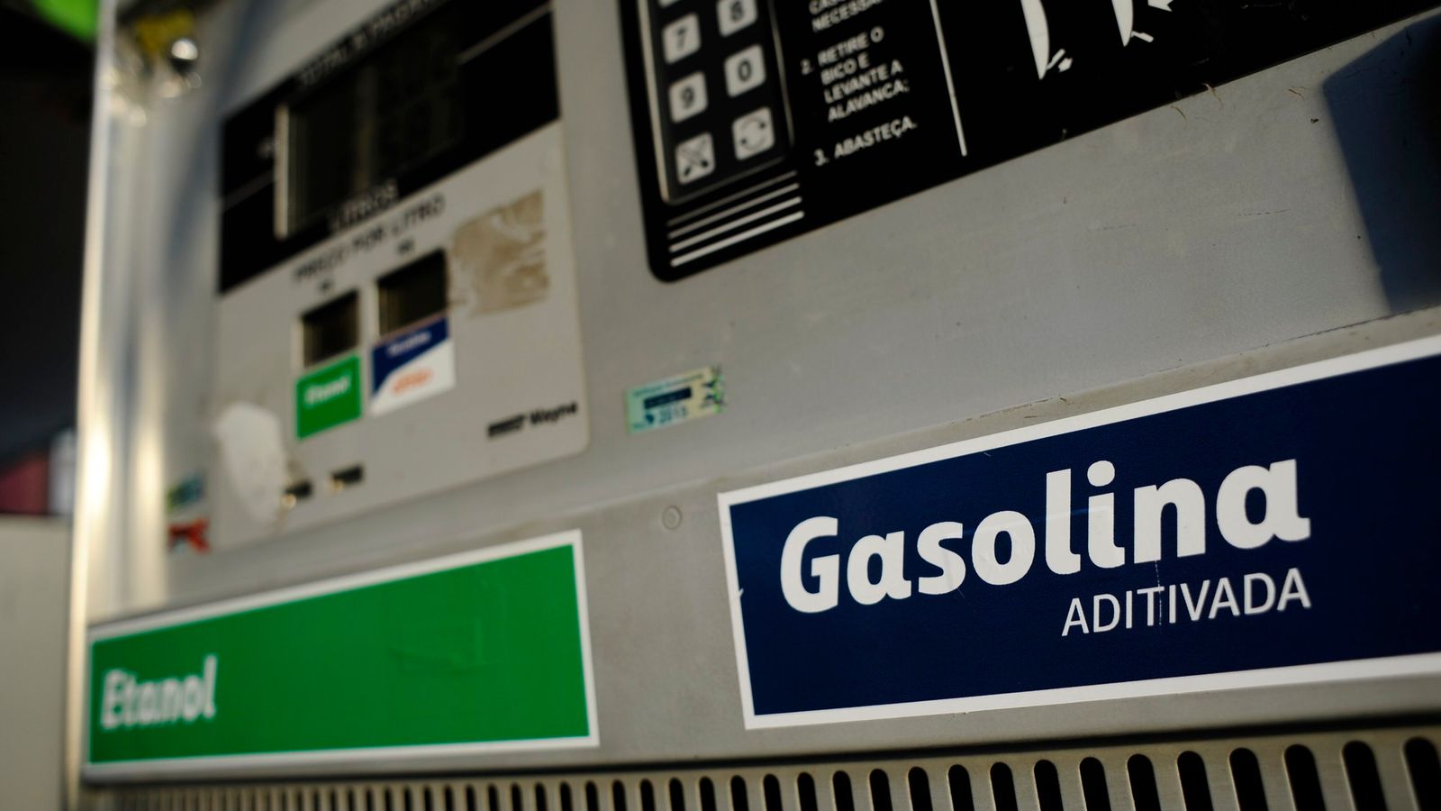 Detalhe de bomba de combustível com as etiquetas “Gasolina aditivada” e “Etanol”